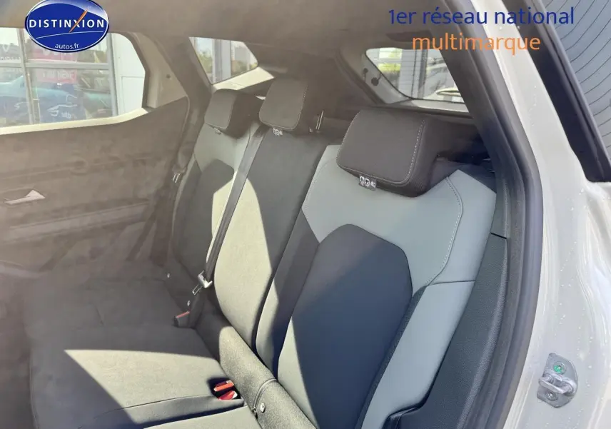 Vue intérieure sur la banquette arrière bicolore gris et noir du Dacia Duster 2025, porte arrière ouverte côté droit.