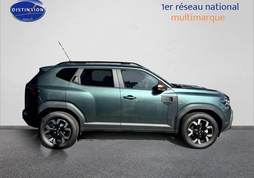 Profil droit d'un Dacia Duster 2025 vert cèdre avec jantes alu et barres de toit visibles sur fond neutre.