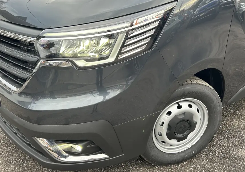 Gros plan sur l'avant droit gris Comète du Renault Trafic Fourgon avec phare LED et jante acier.