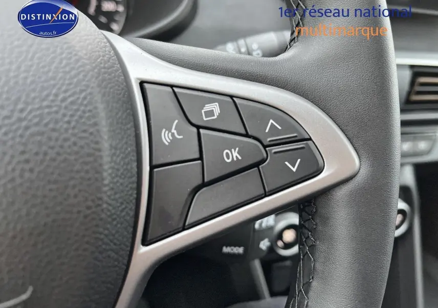 Gros plan sur les commandes multifonctions du volant cuir noir du Dacia Jogger blanc, version 2025.