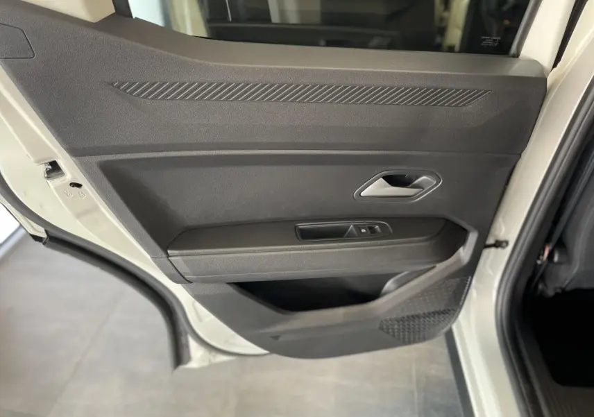 Vue rapprochée de la porte arrière droite beige du Dacia Duster 2025 avec poignée intérieure et commande de vitre.
