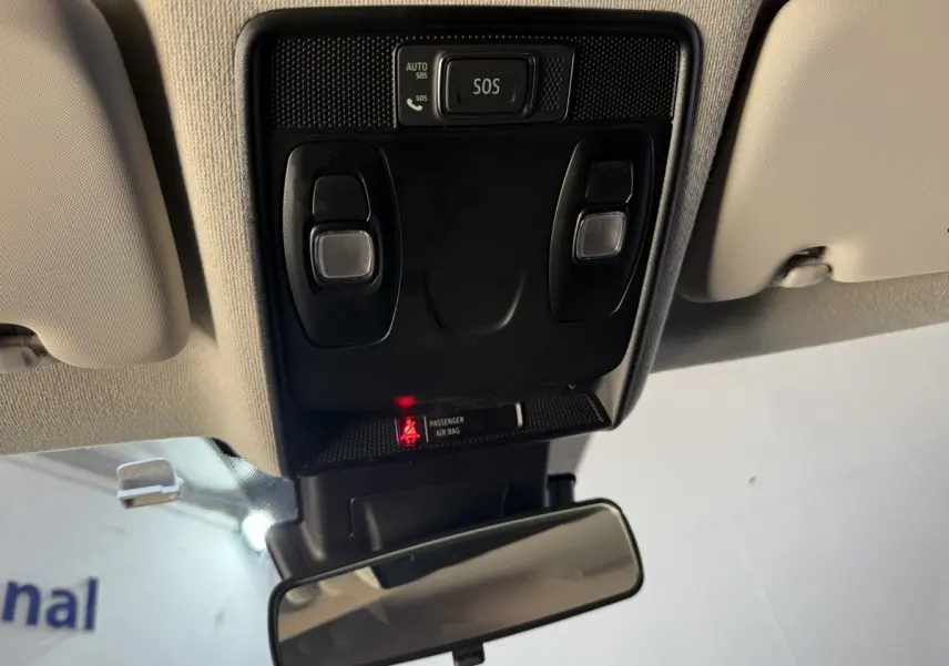 Vue intérieure du plafonnier avec boutons SOS et éclairage, rétroviseur central et plafond beige du Renault Captur bleu 2024.