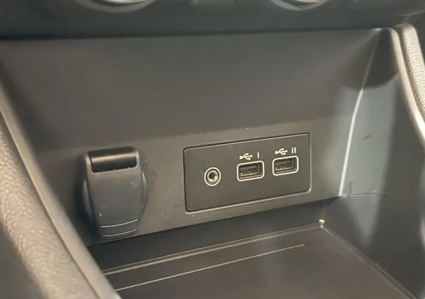 Gros plan sur les ports USB et prise 12V dans l’habitacle du Renault Captur bleu 2024 full hybrid.