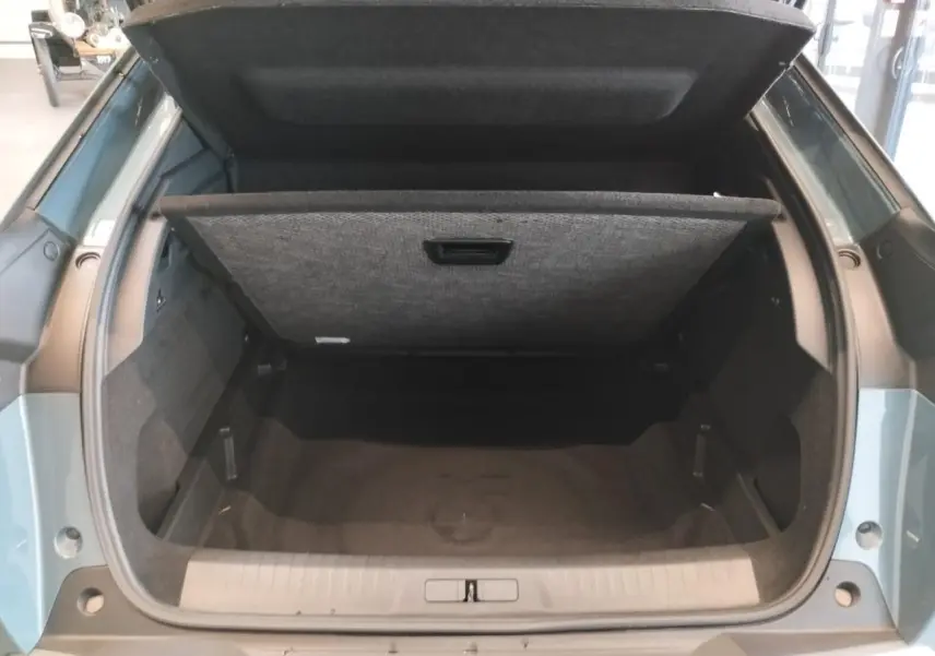 Coffre ouvert vu de l'arrière d'un Peugeot 3008 bleu Azul avec cache-bagages relevé et intérieur noir.