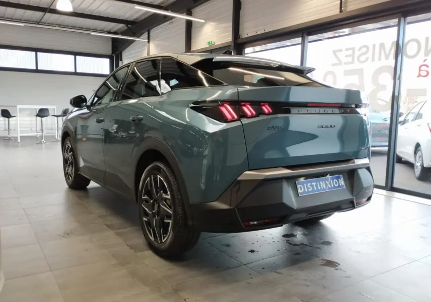 Vue 3/4 arrière droite du Peugeot 3008 hybride bleu Azul avec feux arrière LED à 3 griffes et jantes alliage 19 pouces.