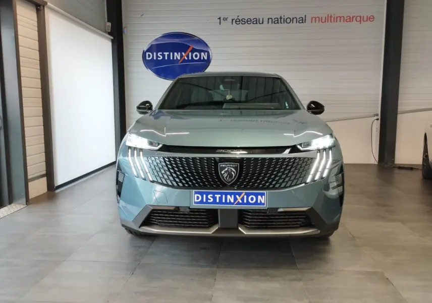 Vue frontale du Peugeot 3008 hybride bleu Azul avec calandre noire à motif géométrique et feux LED à griffes distinctifs.