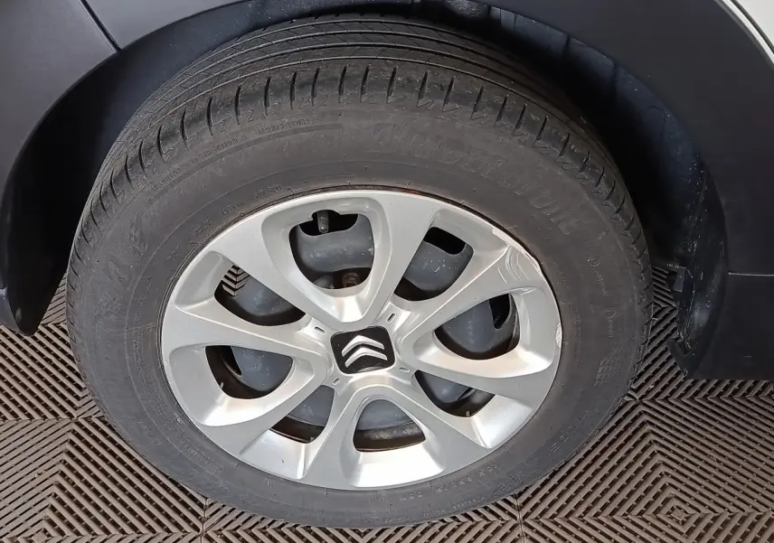 Gros plan sur la roue arrière droite d'une Citroën C3 blanche, avec jante alliage et passage de roue noir.