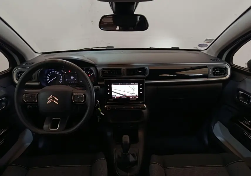 Vue intérieure frontale du tableau de bord noir de la Citroën C3 avec écran tactile de navigation et volant multifonction.