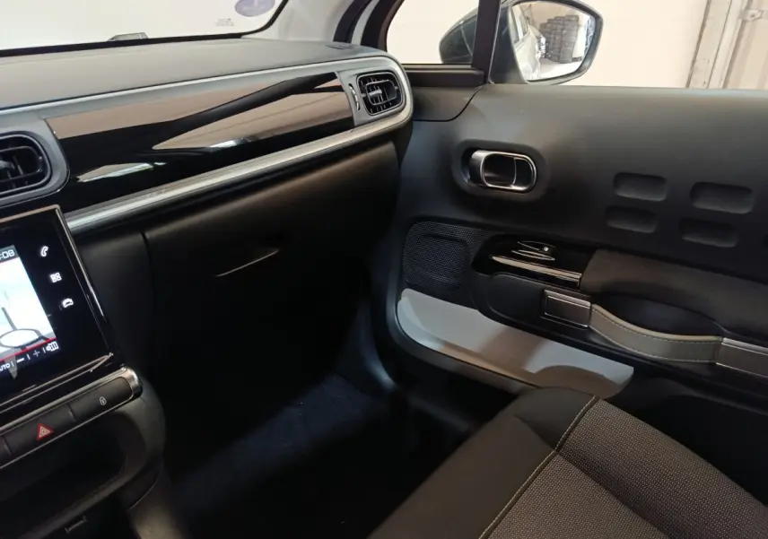 Intérieur avant droit de la Citroën C3 blanche 2020, avec tableau de bord noir brillant et écran tactile.