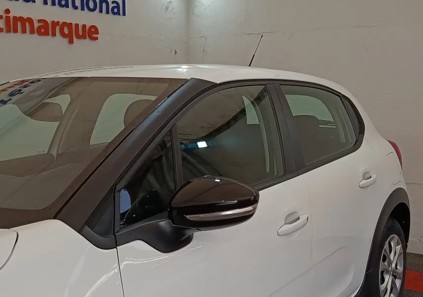 Vue latérale droite d'une Citroën C3 blanche 2020 avec rétroviseur noir et poignées de porte ton caisse.