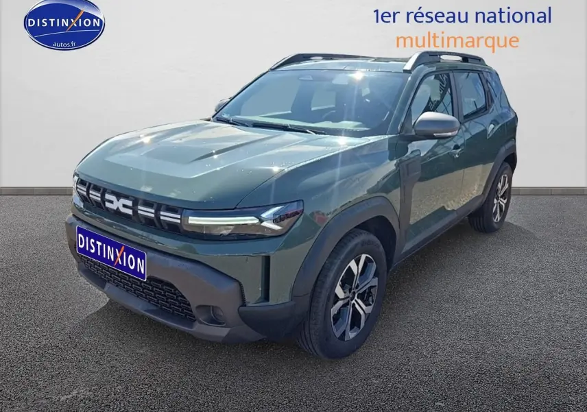SUV Dacia Duster vert kaki en 3/4 avant droit avec jantes alu et barres de toit visibles.