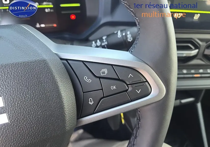 Gros plan sur les commandes multifonctions à droite du volant du Dacia Duster 2025, intérieur moderne noir.