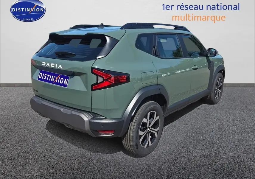 Vue 3/4 arrière droite du Dacia Duster vert kaki 2025 avec barres de toit et jantes alu noires.