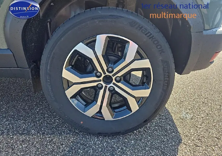 Gros plan sur la roue arrière droite du Dacia Duster vert kaki 2025 avec jante alu bicolore.