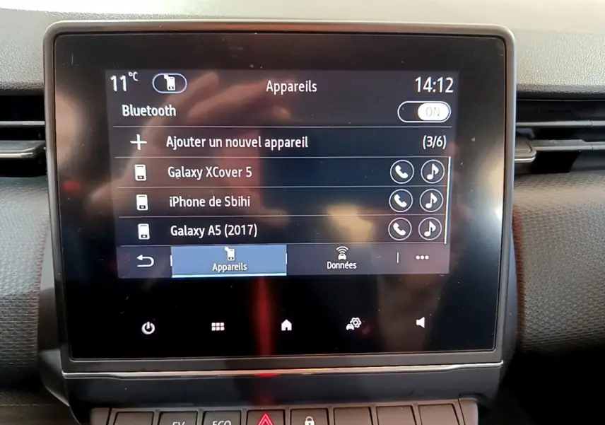 Écran tactile central de la Renault Clio Business E-TECH 140 gris foncé, affichant menu Bluetooth et appareils connectés.
