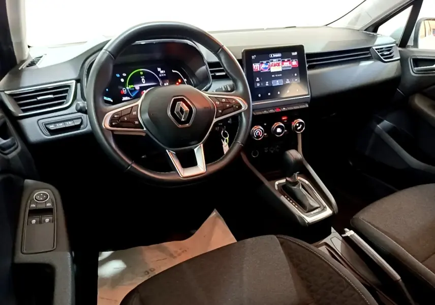 Intérieur noir de la Renault Clio Business E-TECH 140, vue du poste de conduite avec volant cuir et écran tactile central.