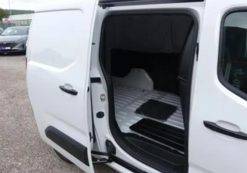 Vue côté droit en plan rapproché du Peugeot Partner XL blanc avec porte latérale ouverte montrant l’espace de chargement vide.