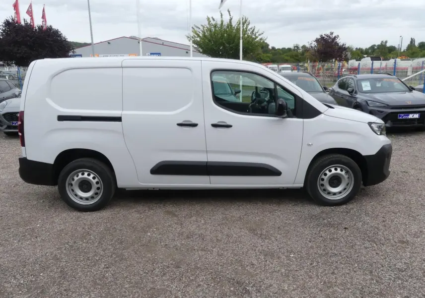 Vue de profil côté droit d'un utilitaire Peugeot Partner blanc avec porte latérale coulissante et jantes tôles grises.