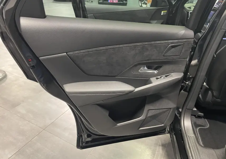 Vue intérieure côté gauche de la porte arrière du DS7 Crossback noir métallisé avec garniture Alcantara et commandes de vitres.