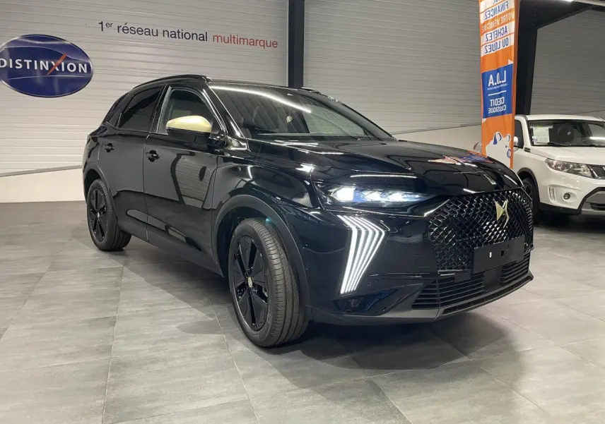 DS7 Crossback noir métallisé en 3/4 avant droit, avec calandre DS Wings et rétroviseurs dorés satinés visibles.