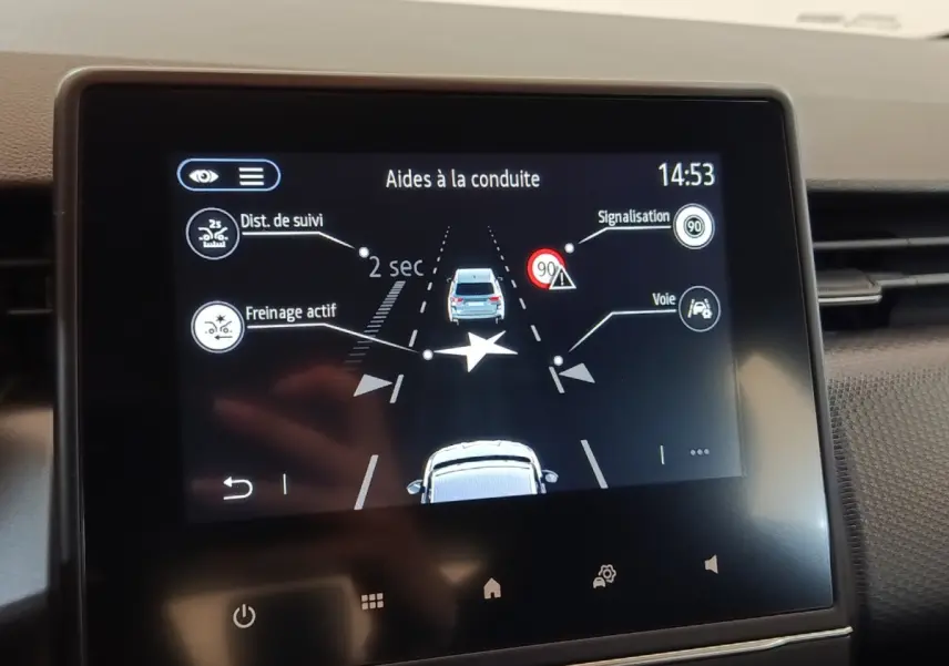 Écran tactile central de la Renault Clio Business blanc montrant l’aide à la conduite avec alertes de distance et voie.