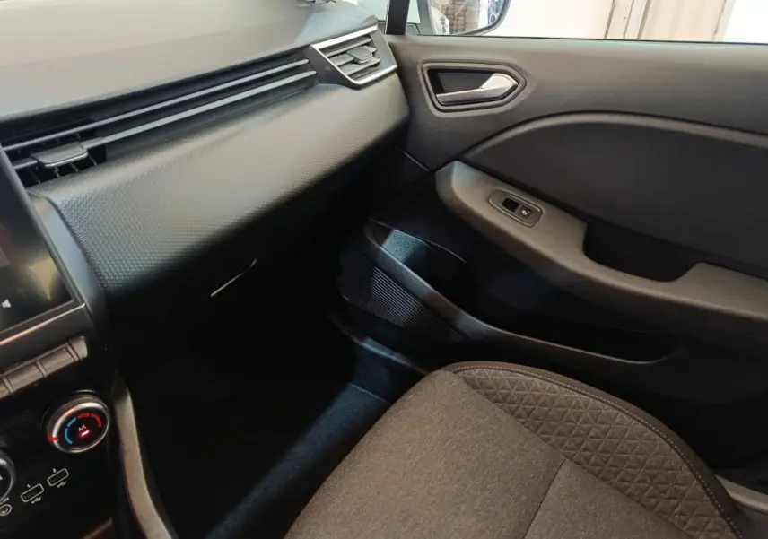 Intérieur côté passager de la Renault Clio Business blanc, tableau de bord texturé et siège tissu gris.