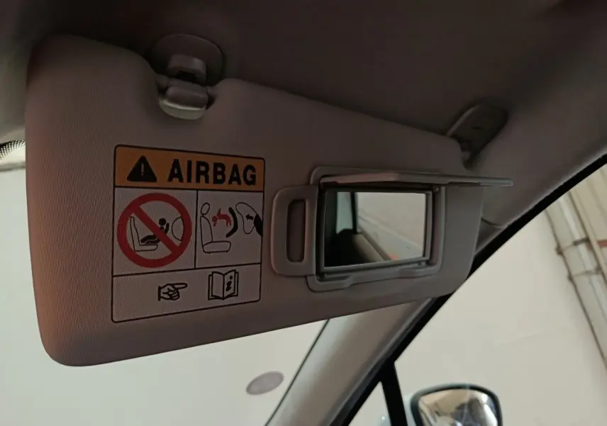 Détail du pare-soleil côté conducteur avec miroir et avertissement airbag dans une Renault Clio blanche 2021.