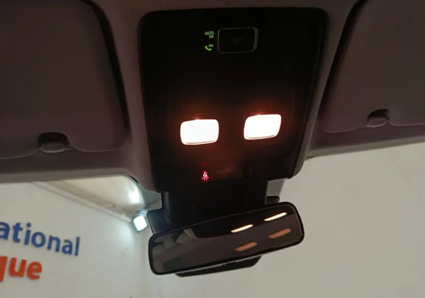 Vue intérieure du plafonnier et du rétroviseur intérieur d’une Renault Clio blanche, avec éclairage allumé.