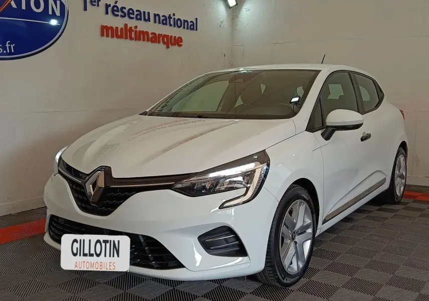 Renault Clio Business blanc vue 3/4 avant droit, avec phares LED et jantes alliage visibles en intérieur showroom.
