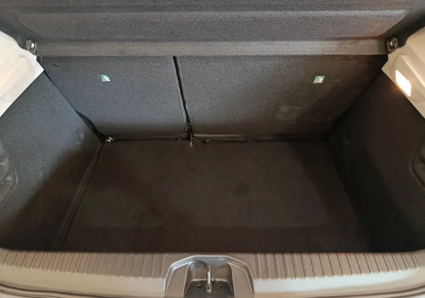 Coffre vide de Renault Clio Business blanc, vue plongeante montrant l'espace de chargement et la banquette arrière rabattable.