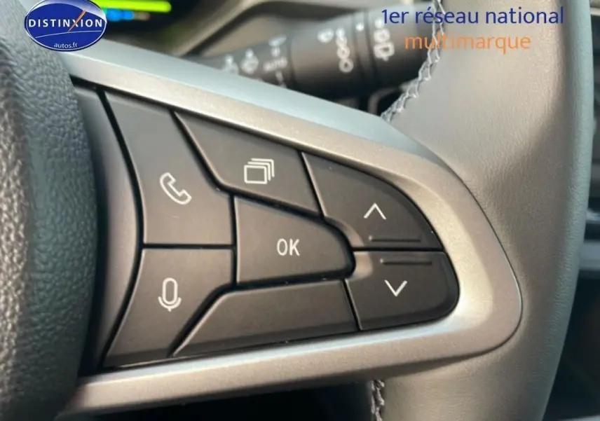 Gros plan sur les commandes multifonctions noires du volant gris du Dacia Bigster 2026, avec boutons appel et navigation.
