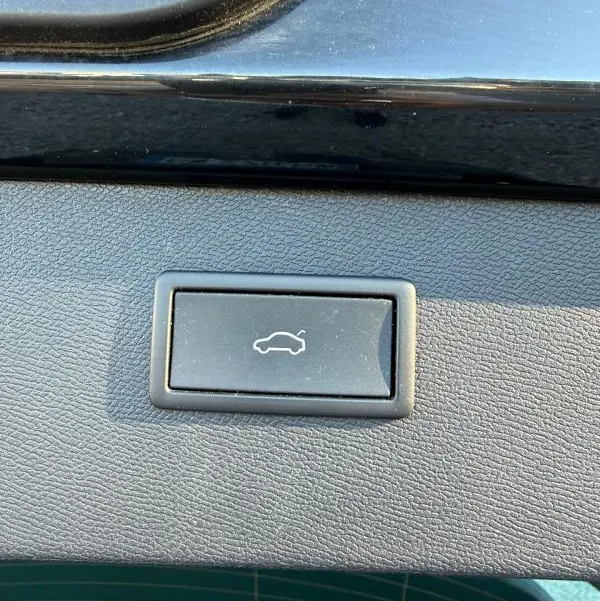 Bouton d'ouverture électrique du coffre sur la garniture intérieure noire du hayon d'un CUPRA Formentor 1.4 e-HYBRID 2024.