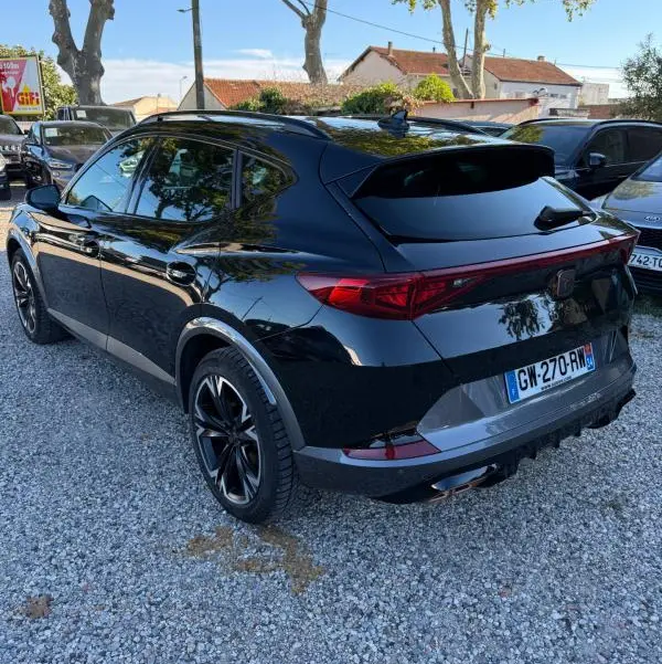 Vue 3/4 arrière droite d'un CUPRA Formentor noir 2024 avec feux arrière allongés et jantes noires distinctives.