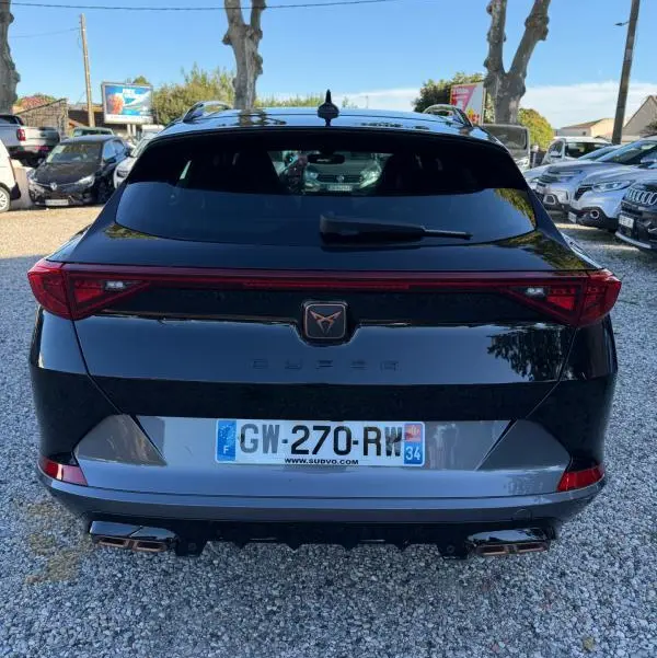 Vue arrière d'une CUPRA Formentor noire 2024 avec feux arrière continus et double sortie d'échappement chromée.