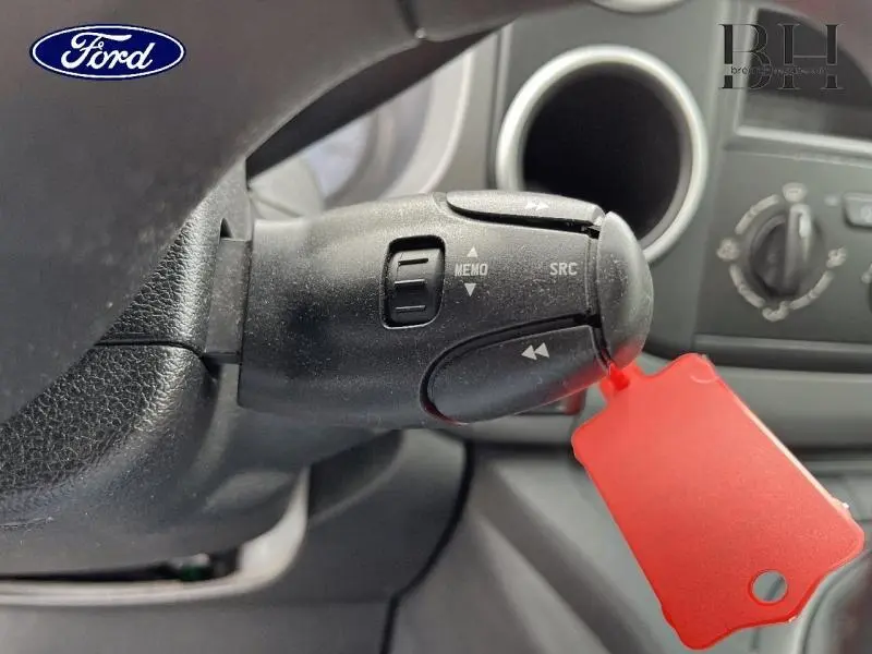 Gros plan sur la commande au volant noir avec étiquette rouge dans l'habitacle d'un Peugeot Partner Tepee blanc Banquise