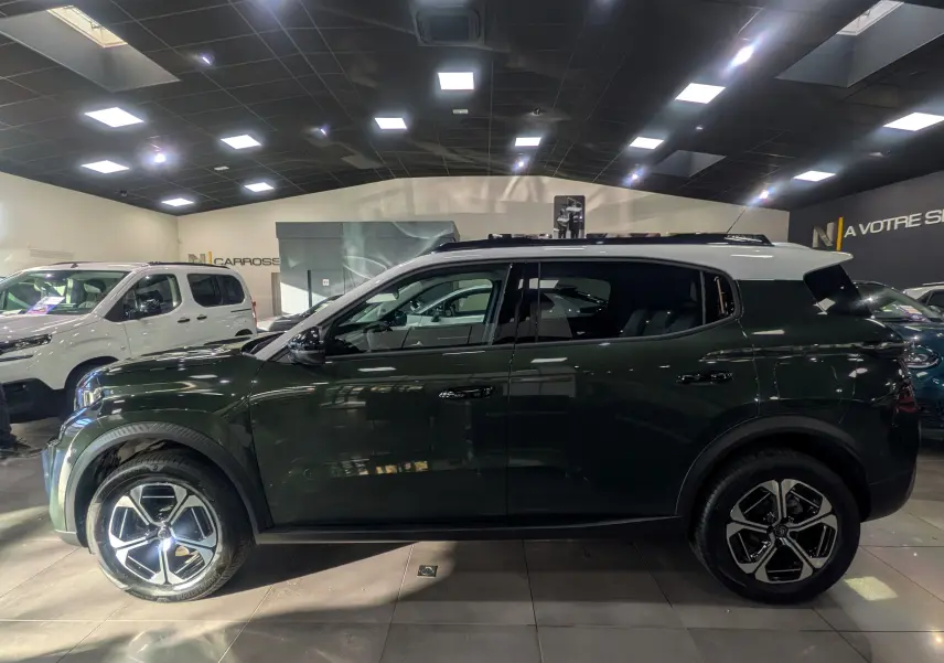 Vue latérale droite d'un Citroën C3 Aircross 2025 vert Montana avec toit blanc et jantes alliage biton.