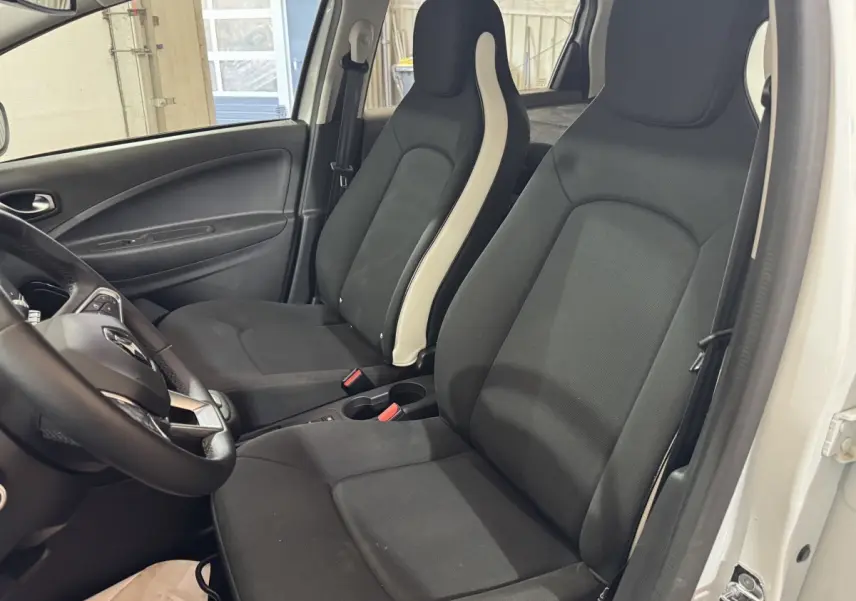 Intérieur de la Renault ZOE Business 2020, vue côté conducteur, sièges noirs avec bandes blanches, portières blanches visibles.