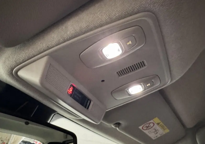Plafonnier intérieur allumé vu de dessous dans une Renault ZOE Business blanc de 2020, avec éclairage de lecture et alerte ceinture.
