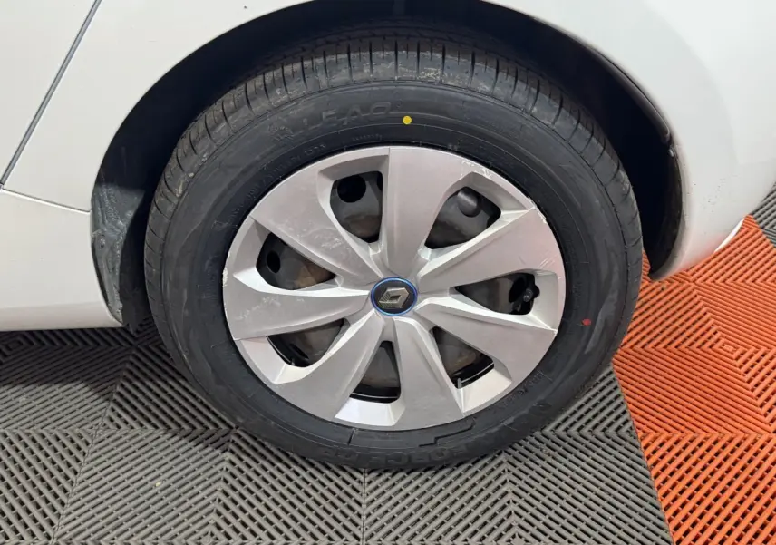 Gros plan sur la roue avant gauche blanche d'une Renault ZOE 2020 avec enjoliveur argenté et logo Renault central.
