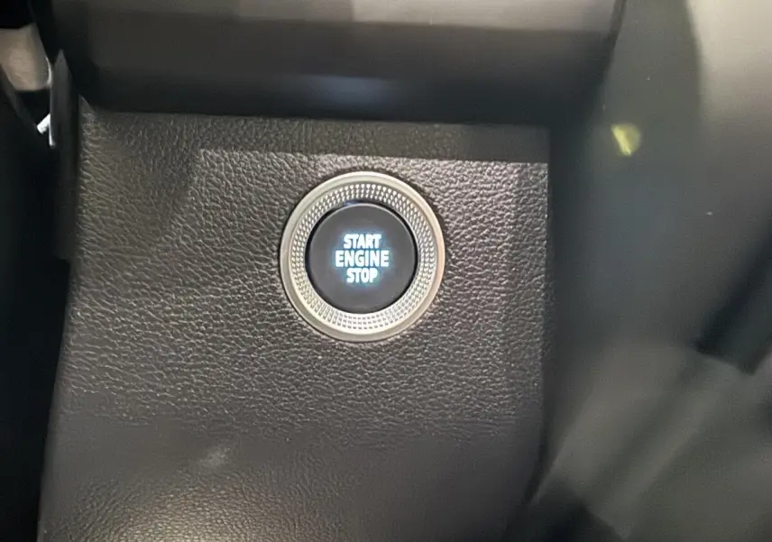 Gros plan sur le bouton démarrage "Start Engine Stop" intégré dans le tableau de bord noir du Renault ZOE blanc 2020.