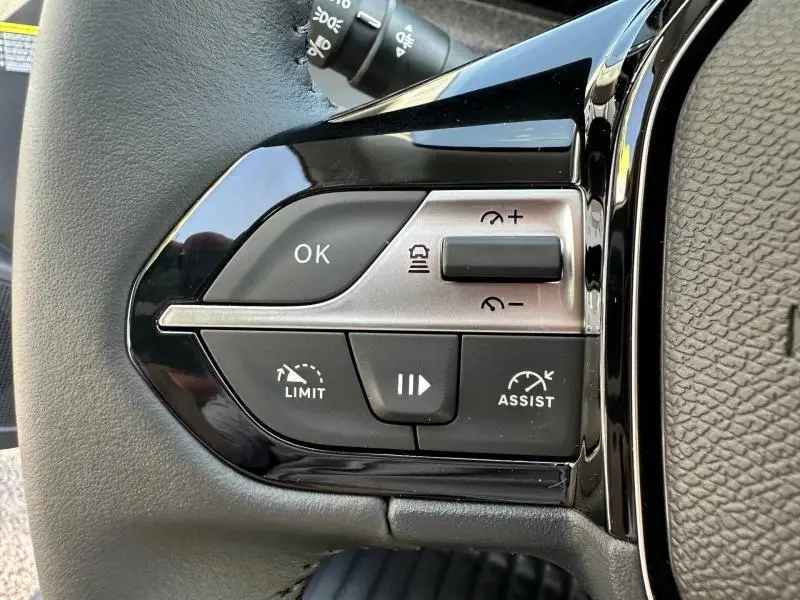 Gros plan sur les commandes de régulateur de vitesse au volant de la Peugeot 308 gris Artense, version 2025.