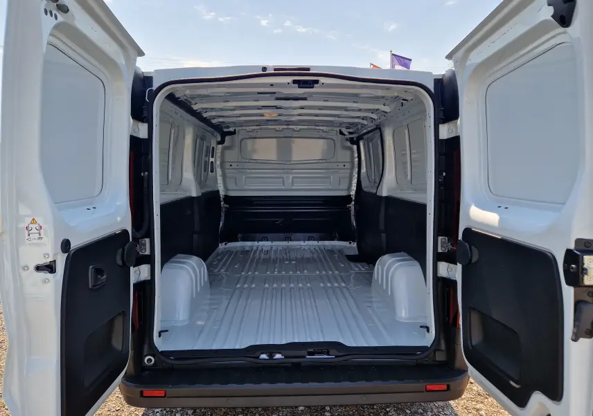 Vue arrière ouverte du Renault Trafic Fourgon blanc L2H1, montrant l’espace de chargement vide et les portes battantes.