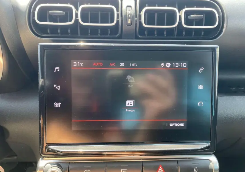 Écran tactile central allumé avec commandes climatisation et aérateurs rectangulaires dans l'habitacle d'une Citroën C3 Aircross 2023.