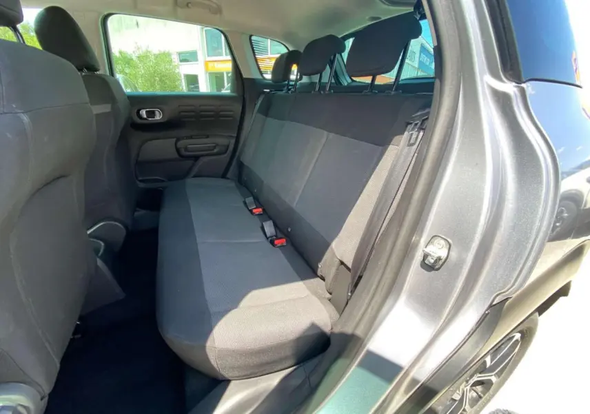 Vue intérieure côté droit sur la banquette arrière noire du Citroën C3 Aircross gris Artense avec toit blanc.