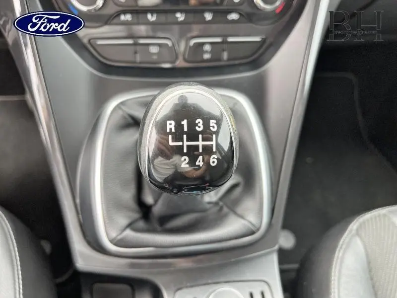 Le levier de vitesses manuel noir du Ford Kuga 2.0 TDCi gris Magnetic vu de dessus avec coutures apparentes.