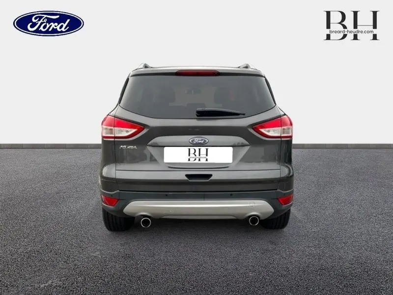 Vue arrière du Ford Kuga gris Magnetic de 2015, avec double sortie d'échappement chromée et feux arrière distinctifs.