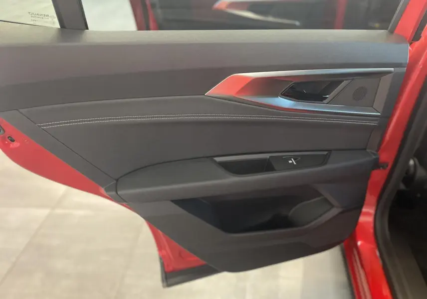 Vue intérieure de la porte avant gauche rouge du Renault Rafale 2025 avec garniture noire et surpiqûres blanches.