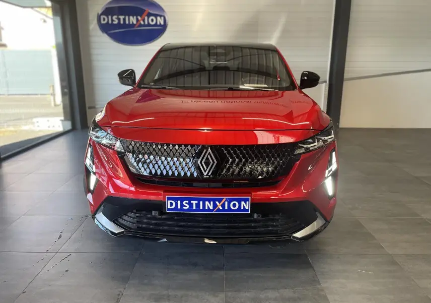 Vue de face du Renault Rafale rouge à toit noir avec calandre 3D et feux LED allumés en showroom.