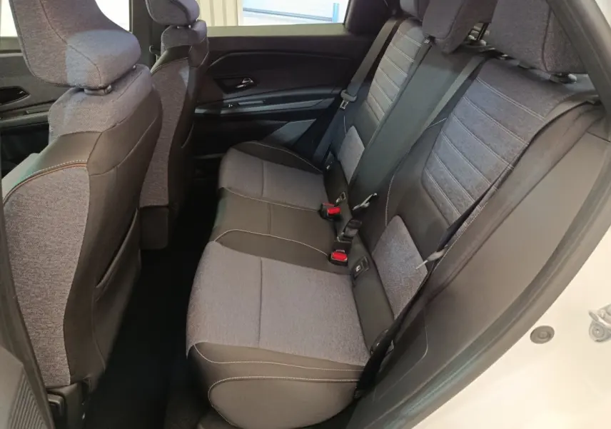 Vue intérieure côté droit sur la banquette arrière grise et noire du Renault R5 Techno 150 ch 2025, porte blanche ouverte.