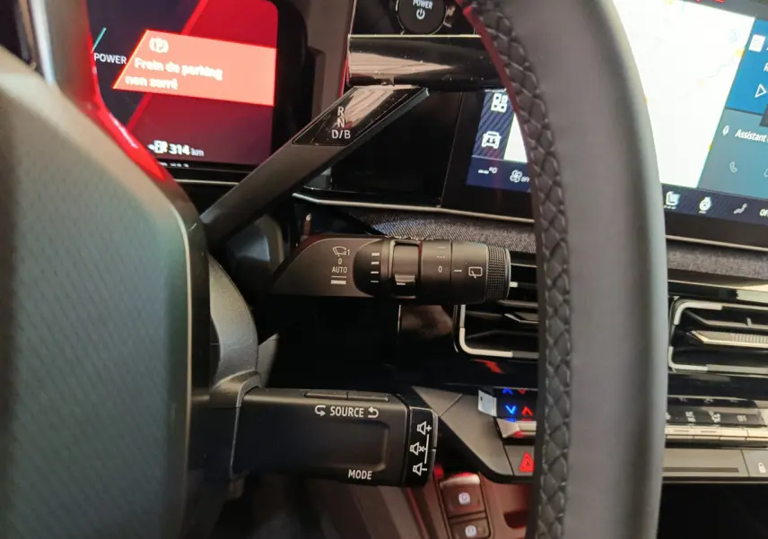 Vue rapprochée du volant et des commandes au tableau de bord de la Renault R5 Techno 150 ch blanc, affichage numérique.